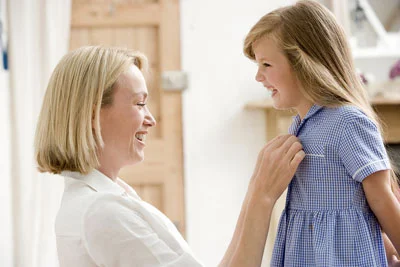 Mom dressing her daughter